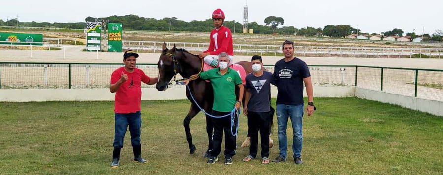Vencedor na premiação, com a pista e o partidor ao fundo